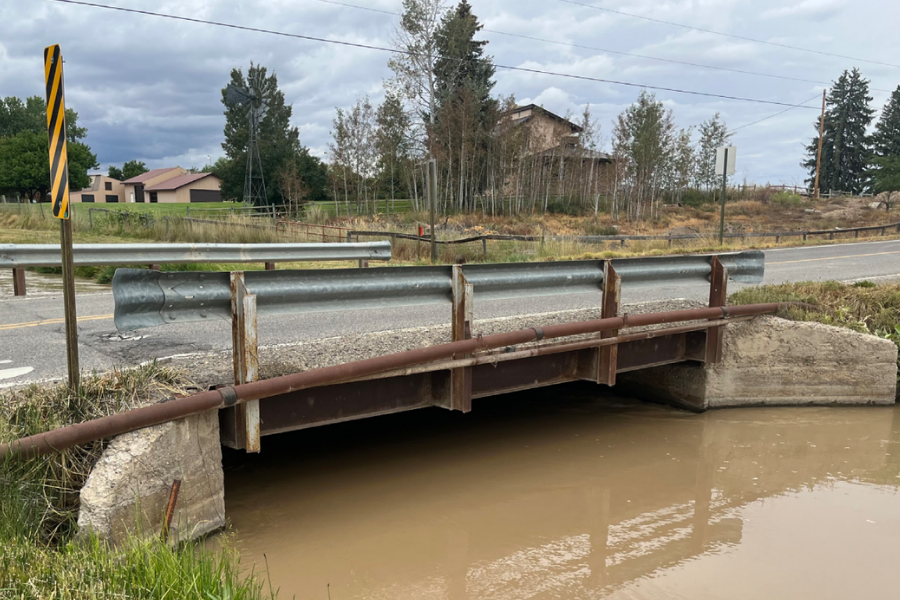 Photo of a bridge over the Highline Canal on J Road near 23 Road north of Grand Junction. Trees and houses are in the background.